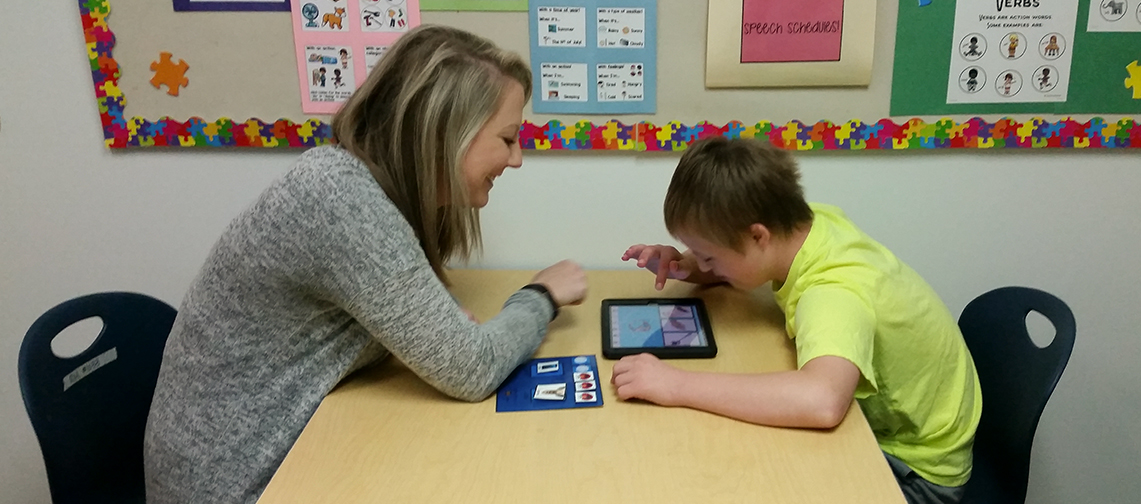 Speech Pathologist using assistive technology to teach a Monarch student with Autism Spectrum Disorder 